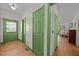 Bright hallway featuring unique green doors and hardwood floors, creating a welcoming atmosphere at 2409 Hodges Rd, Burlington, NC 27217
