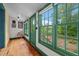 Hallway with natural light, wood floors, green trim, and views of the outdoors at 2409 Hodges Rd, Burlington, NC 27217