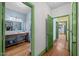 Hallway view to bathroom and kitchen, featuring hardwood floors and natural light at 2409 Hodges Rd, Burlington, NC 27217