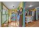 Bright hallway featuring yellow walls, decorative furniture and decor, with kitchen access at 2409 Hodges Rd, Burlington, NC 27217