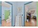 Hallway view of bathroom and bedroom featuring hardwood floors and bright color palette at 2409 Hodges Rd, Burlington, NC 27217