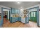 Bright kitchen featuring blue cabinetry, wooden countertops, a farmhouse sink, and a vintage green door at 2409 Hodges Rd, Burlington, NC 27217