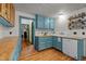 Charming kitchen featuring blue cabinets, wooden countertops, and white appliances at 2409 Hodges Rd, Burlington, NC 27217