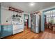 Kitchen features a stainless steel refrigerator and white appliances against white walls and wood flooring at 2409 Hodges Rd, Burlington, NC 27217