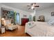 Comfortable bedroom boasts wooden floors, bookshelves, and ceiling fan at 2409 Hodges Rd, Burlington, NC 27217