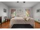 Bright main bedroom features hardwood floors, neutral walls, decorative plates, and soft window treatments at 2409 Hodges Rd, Burlington, NC 27217
