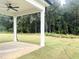 Covered back porch with ceiling fan overlooking a spacious, green backyard and wooded area at 283 Golfview Avenue, Benson, NC 27504