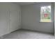 Bright, white bedroom with large window offering natural light and double door closet at 283 Golfview Avenue, Benson, NC 27504