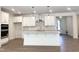 The bright, modern kitchen features an island, granite countertops, stainless steel appliances, and white cabinets at 283 Golfview Avenue, Benson, NC 27504