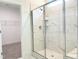 Modern bathroom features a tiled walk-in shower with glass doors and a view of the walk-in closet at 283 Golfview Avenue, Benson, NC 27504