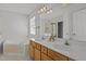 Bright bathroom featuring double vanity, soaking tub, and large mirror for a spa-like experience at 3509 Archdale Dr, Raleigh, NC 27614