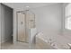 Bathroom featuring a shower with glass doors, a soaking tub and a window for ample natural light at 3509 Archdale Dr, Raleigh, NC 27614