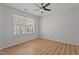 Bedroom featuring wood floors, a ceiling fan, and a large window for ample natural light at 3509 Archdale Dr, Raleigh, NC 27614