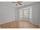 Cozy bedroom features wood flooring, a ceiling fan, and a bright bay window at 3509 Archdale Dr, Raleigh, NC 27614