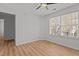 Bedroom featuring wood floors, a ceiling fan, and a large window for ample natural light at 3509 Archdale Dr, Raleigh, NC 27614