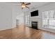 View of the living room flowing into the kitchen, featuring hardwood floors and a fireplace at 3509 Archdale Dr, Raleigh, NC 27614