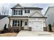 Charming two-story home showcasing a well-manicured lawn and a welcoming entrance, with a white garage door at 354 Bluejay St, Clayton, NC 27520