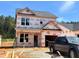 Two-story home under construction, featuring a visible garage and stairs leading to the front door on a sunny day at 354 Bluejay St, Clayton, NC 27520