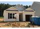 New construction home with light siding, black shutters, and an open garage, set in a partially landscaped yard at 362 Bluejay St, Clayton, NC 27520