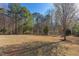 Picturesque backyard with mature trees, swing set, and a soccer goal perfect for Gathering enjoyment at 3708 Tansley St, Wake Forest, NC 27587
