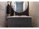 Stylish powder room featuring wallpaper, gray vanity and a round mirror with brass trim at 3708 Tansley St, Wake Forest, NC 27587