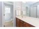 Bright bathroom featuring a wood vanity, large mirror, white towels, and neutral-toned tile flooring at 3708 Tansley St, Wake Forest, NC 27587