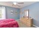 Cozy bedroom with light blue walls, light colored wooden dresser, and a ceiling fan with a light fixture at 3708 Tansley St, Wake Forest, NC 27587