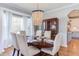 Bright dining room with a modern chandelier, a dark wood table, and plush upholstered chairs at 3708 Tansley St, Wake Forest, NC 27587