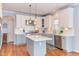 A stylish kitchen features a center island, stainless steel appliances, and custom two-tone cabinetry at 3708 Tansley St, Wake Forest, NC 27587