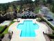 Aerial view of a uniquely shaped community pool and clubhouse with ample parking and manicured landscaping at 3708 Tansley St, Wake Forest, NC 27587