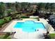 Community pool featuring a unique layout, bordered by lush greenery, offering a refreshing and inviting recreational space at 3708 Tansley St, Wake Forest, NC 27587