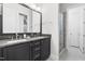 Bathroom featuring a double vanity, stone countertop, stainless steel faucets, a large mirror, and a glass shower at 3847 Stoneridge Forest Dr, Raleigh, NC 27612