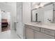 Bathroom with large mirror, neutral vanity, tile flooring, and doorway view to the bedroom at 3847 Stoneridge Forest Dr, Raleigh, NC 27612