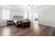 Well-lit bedroom features hardwood floors and a ceiling fan with furniture including a bed and leather chest at 3847 Stoneridge Forest Dr, Raleigh, NC 27612