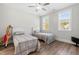 Bright bedroom featuring two twin beds, ceiling fan and natural light creating a welcoming space at 3847 Stoneridge Forest Dr, Raleigh, NC 27612