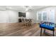 Dining area featuring hardwood flooring, a ceiling fan, windows for natural light, and a foosball table at 3847 Stoneridge Forest Dr, Raleigh, NC 27612