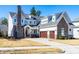 Charming two-story home with stone accents, three-car garage, well-manicured lawn, and a welcoming covered front porch at 3847 Stoneridge Forest Dr, Raleigh, NC 27612