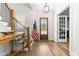 Bright foyer with hardwood floors, staircase, console table, and natural light streaming through the front door at 3847 Stoneridge Forest Dr, Raleigh, NC 27612