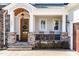 Inviting covered front porch with rocking chairs, stone accents, and wood door with wreath, exuding curb appeal at 3847 Stoneridge Forest Dr, Raleigh, NC 27612