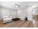 Bright living room with hardwood floors, a large white couch, and natural light at 3847 Stoneridge Forest Dr, Raleigh, NC 27612