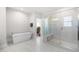 Bright bathroom featuring a soaking tub and a glass-enclosed shower with tiled walls and a bench at 3847 Stoneridge Forest Dr, Raleigh, NC 27612