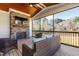 Comfortable screened porch featuring a stone fireplace, TV, ceiling fan, and wooded backyard views at 3847 Stoneridge Forest Dr, Raleigh, NC 27612