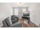 Sitting room with hardwood floors, soft natural lighting, two comfy armchairs, and a wall-mounted television at 3847 Stoneridge Forest Dr, Raleigh, NC 27612