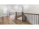 Upstairs landing showing staircase and a large window, creating an open and airy transition between floors at 3847 Stoneridge Forest Dr, Raleigh, NC 27612