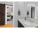 Elegant bathroom with granite countertop, dark wood cabinets, barn door entry, and decorative mirror at 400 W North St # 1204, Raleigh, NC 27603