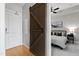 Cozy bedroom featuring a barn door entry, neutral walls, soft carpet, and a comfortable bed at 400 W North St # 1204, Raleigh, NC 27603
