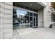 Modern condominium entrance with glass doors, a stone facade, and exterior lighting fixtures at 400 W North St # 1204, Raleigh, NC 27603