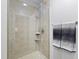 Modern shower with beige tile surround, a glass door, and sleek fixtures in a bright bathroom at 400 W North St # 1204, Raleigh, NC 27603