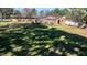 Large, unkept backyard with shade and a building in the background at 408 Rand Rd, Raleigh, NC 27603