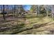 Large backyard with mostly dead grass, trees, and a broken wooden fence at 408 Rand Rd, Raleigh, NC 27603